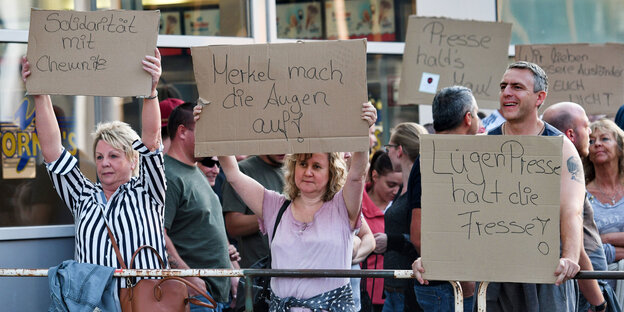 Leute halten Schilder hoch Leute halten Schilder hoch