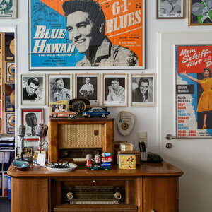 Ein Elvis-Poster hängt an einer Wand, darunter alte Musikabspielgeräte Ein Elvis-Poster hängt an einer Wand, darunter alte Musikabspielgeräte