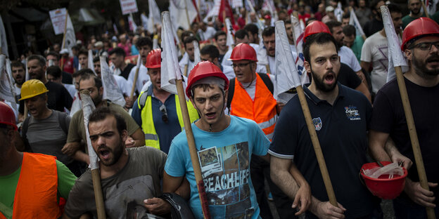Demonstranten mit Fahnen und Helmen Demonstranten mit Fahnen und Helmen