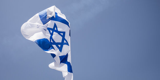 Eine israelische Flagge weht vor blauem Himmel Eine israelische Flagge weht vor blauem Himmel