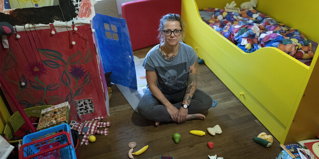 Rike Drust sitzt in einem Kinderzimmer. Rike Drust sitzt in einem Kinderzimmer.