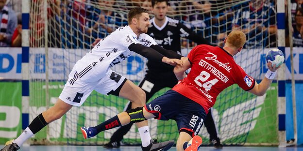 Kiels Hendrik Pekeler versucht, dem heranstürmenden Flensburger Jim Gottfridsson den Ball abzujagen. Kiels Hendrik Pekeler versucht, dem heranstürmenden Flensburger Jim Gottfridsson den Ball abzujagen.