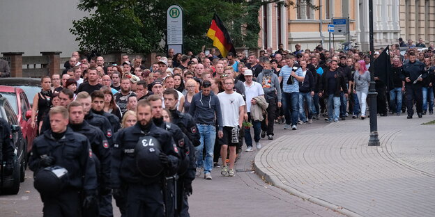 Menschen laufen in einem Zug auf einer Straße Menschen laufen in einem Zug auf einer Straße