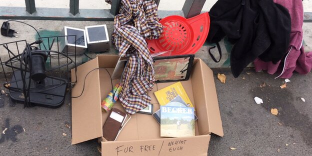 In und um eine Pappkiste, auf der "For free" steht, liegt Flohmarkzeug verteilt In und um eine Pappkiste, auf der "For free" steht, liegt Flohmarkzeug verteilt