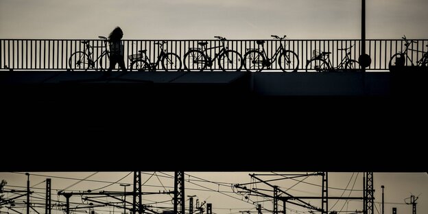 eine Frau läuft in Berlin einsam über eine Brücke in der Dämmerung eine Frau läuft in Berlin einsam über eine Brücke in der Dämmerung