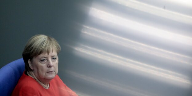 Angela Merkel hat etwas hellrotes an. Neben ihr helle Lichtstreifen Angela Merkel hat etwas hellrotes an. Neben ihr helle Lichtstreifen