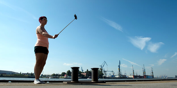 Eine Frau macht im Hamburger Hafen ein Selfie. Eine Frau macht im Hamburger Hafen ein Selfie.