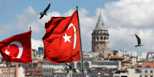 Zwei türkische Flaggen wehen im Wind. Im Hintergrund ist der Galataturm in Istanbul zu sehen. Zwei türkische Flaggen wehen im Wind. Im Hintergrund ist der Galataturm in Istanbul zu sehen.