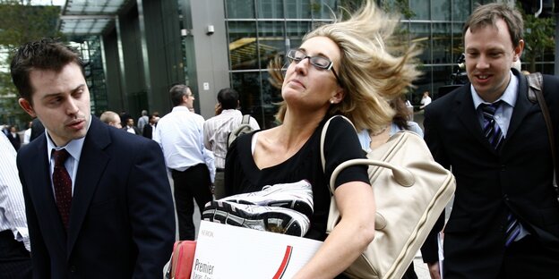 In New York verlassen zwei Männer und eine Frau das Gebäude der Lehman Brothers In New York verlassen zwei Männer und eine Frau das Gebäude der Lehman Brothers