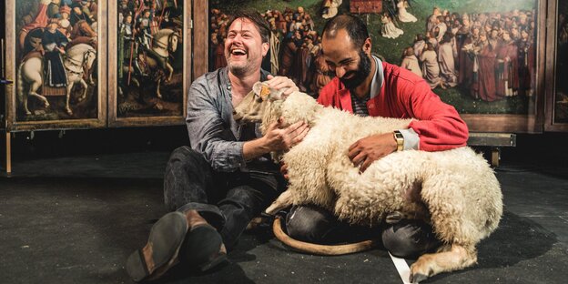 Milo Rau (l.) mit dem Kunststudenten Bilal Alnouri und einem Schaf vor einer Reproduktion des Genter Altars Milo Rau (l.) mit dem Kunststudenten Bilal Alnouri und einem Schaf vor einer Reproduktion des Genter Altars