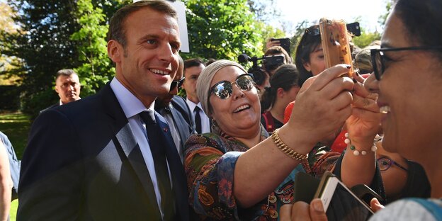 Emmanuel Macron (l), Präsident von Frankreich, lässt sich während des Tags der Offenen Tür im Elyseepalast mit einer Frau fotografieren. Emmanuel Macron (l), Präsident von Frankreich, lässt sich während des Tags der Offenen Tür im Elyseepalast mit einer Frau fotografieren.