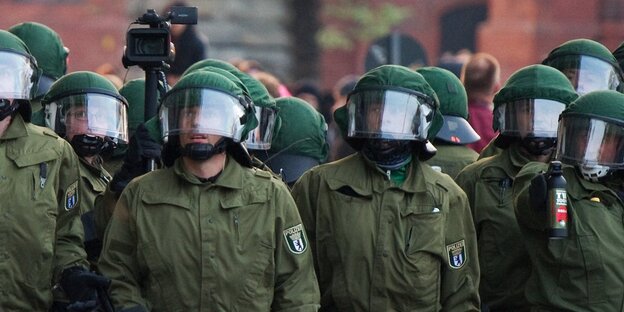 Mehrere behelmte Polizisten Mehrere behelmte Polizisten