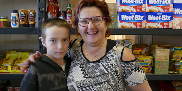 Frau und Junge stehen vor Supermarktregalen Frau und Junge stehen vor Supermarktregalen