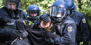 Polizisten halten einen Aktivisten fest. Behörden räumen auch am Mittwoch die Baumhäuser der Umweltaktivisten im Hambacher Forst.
