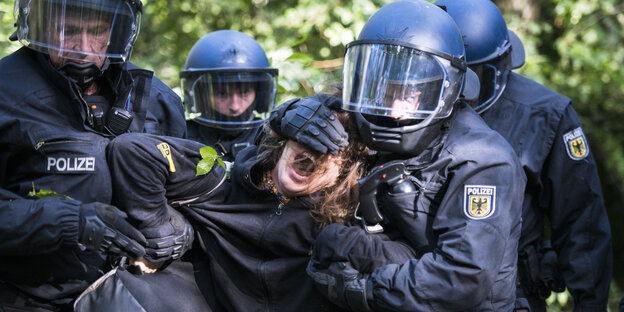 Polizisten halten einen Aktivisten fest. Behörden räumen auch am Mittwoch die Baumhäuser der Umweltaktivisten im Hambacher Forst. Polizisten halten einen Aktivisten fest. Behörden räumen auch am Mittwoch die Baumhäuser der Umweltaktivisten im Hambacher Forst.