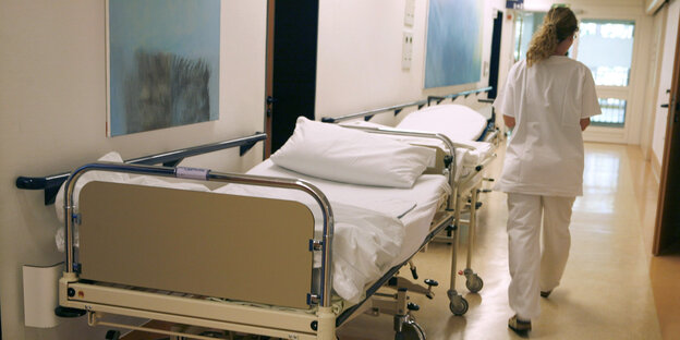 Eine Krankenpflegerin geht über einen Krankenhausflur. Eine Krankenpflegerin geht über einen Krankenhausflur.