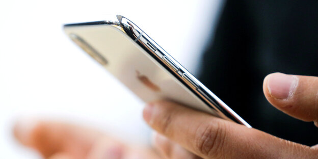 Jemand hält ein Iphone in der Hand Jemand hält ein Iphone in der Hand