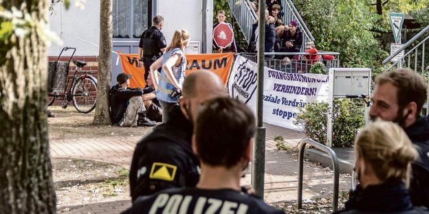 Demonstranten sitzen auf den Treppen eines Hauseingangs. Demonstranten sitzen auf den Treppen eines Hauseingangs.
