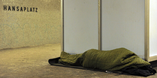 Ein Obdachloser schläft auf dem Fußboden in einer Berliner U-Bahn-Station. Ein Obdachloser schläft auf dem Fußboden in einer Berliner U-Bahn-Station.