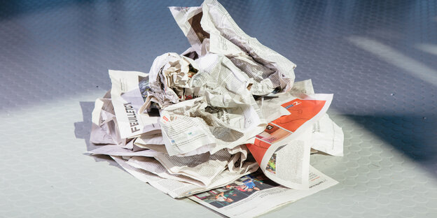 Eine zerknüllte Zeitung liegt auf dem Boden Eine zerknüllte Zeitung liegt auf dem Boden