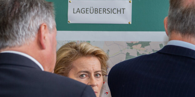 Verteidigungsministerin Ursula von der Leyen (CDU) blickt zwischen den Schultern zweier Jackettträger hindurch. Verteidigungsministerin Ursula von der Leyen (CDU) blickt zwischen den Schultern zweier Jackettträger hindurch.