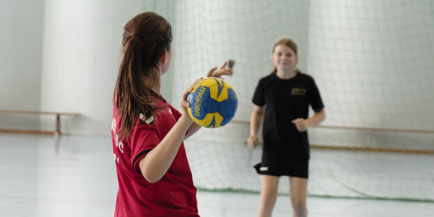 Ein Mädchen wirft einen Handball Ein Mädchen wirft einen Handball