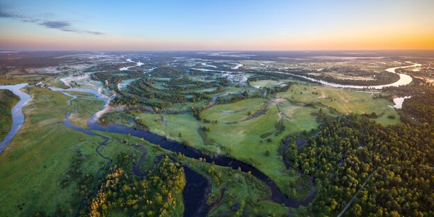 Grüne Landschaft mit einem Fluss von oben betrachtet