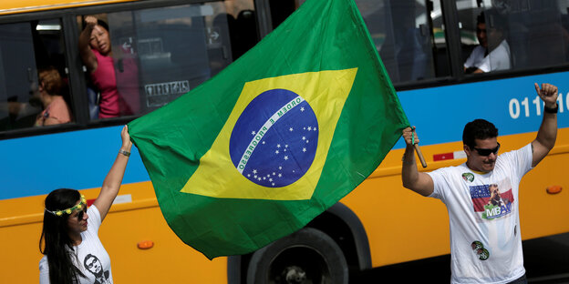 Zwei Wahlhelfer schwenken die brasilianische Flagge Zwei Wahlhelfer schwenken die brasilianische Flagge