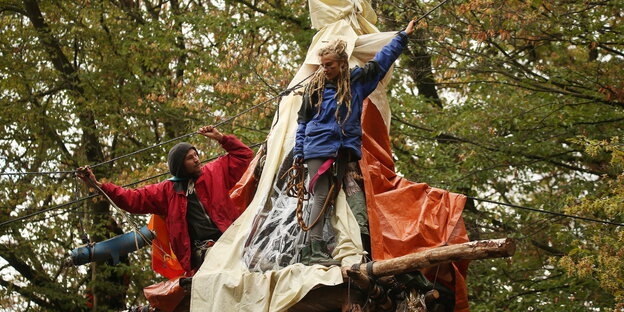 Im Hambacher Forst stehen Demonstranten angeseilt auf einem Tripod. Im Hambacher Forst stehen Demonstranten angeseilt auf einem Tripod.