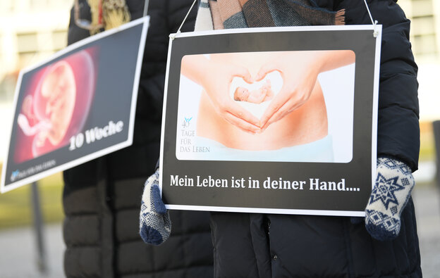 Eine Person hält ein Protest-Schild