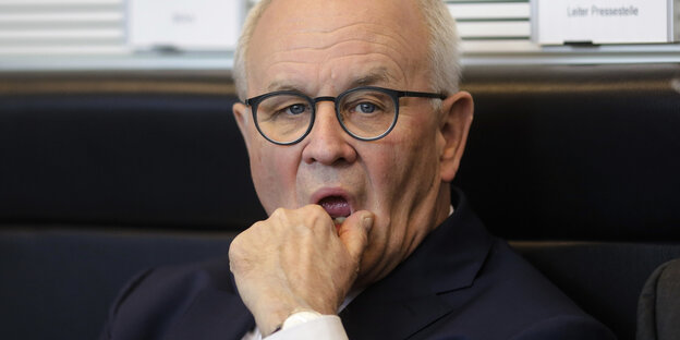 Ein Mann fässt sich mit der Hand ans Kinn Ein Mann fässt sich mit der Hand ans Kinn
