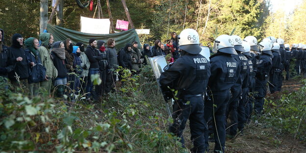 PolizistInnen stehen AktivistInnen im Hambacher Forst gegenüber PolizistInnen stehen AktivistInnen im Hambacher Forst gegenüber
