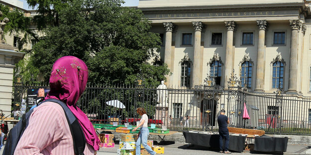 Eine Frau mit Kopftuch geht an der Humboldt-Universität an der Straße Unter den Linden in Berlin vorbe Eine Frau mit Kopftuch geht an der Humboldt-Universität an der Straße Unter den Linden in Berlin vorbe