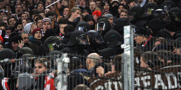 Behelmte Polizist*innen stehen im St. Pauli-Block