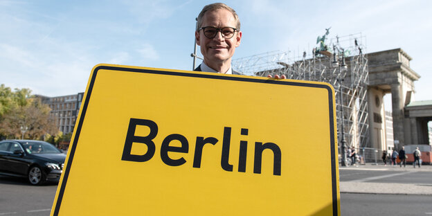 Michael MÜller trägt ein Berliner Ortsschild Michael MÜller trägt ein Berliner Ortsschild