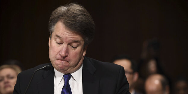 Brett Kavanaugh guckt mit aufgepusteten Wangen nach unten