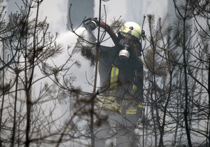 Ein Feuerwehrmann löscht einen Brand im Wald Ein Feuerwehrmann löscht einen Brand im Wald