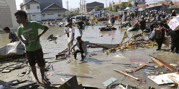 Menschen stehen in Trümmern nach den Erdbeben und dem Tsunami in Palu Menschen stehen in Trümmern nach den Erdbeben und dem Tsunami in Palu
