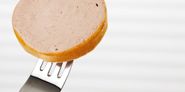 Eine Scheibe Leberwurst auf einer Gabel Eine Scheibe Leberwurst auf einer Gabel