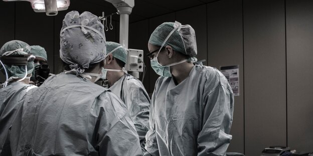 Ärzte stehen an einem Operationstisch Ärzte stehen an einem Operationstisch
