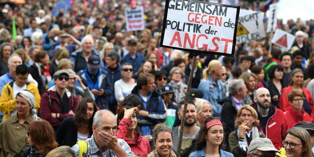 Viele Menschen demonstrieren, aus der Menge ragt ein Schild mit der Aufschrift: Gemeinsam gegen die Politik der Angst Viele Menschen demonstrieren, aus der Menge ragt ein Schild mit der Aufschrift: Gemeinsam gegen die Politik der Angst