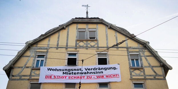 Haus mit Transparent, auf dem steht: Wohnungsnot, Verdränung, Mietenwahnsinn, die Stadt schaut zu, wir nicht Haus mit Transparent, auf dem steht: Wohnungsnot, Verdränung, Mietenwahnsinn, die Stadt schaut zu, wir nicht