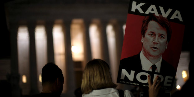Vor dem Obersten Gericht in Washington hält eine Frau ein Plakat mit dem Gesicht von Brett Kavanaugh und der Aufschrift "Kava Nope"