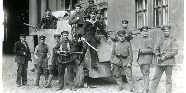 Menschen stehen auf und vor einem Panzerwagen Menschen stehen auf und vor einem Panzerwagen