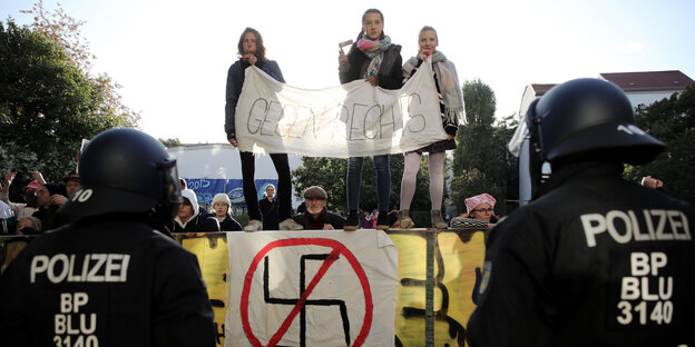 Drei junge Menschen mit einem Plakat gegen Nazis Drei junge Menschen mit einem Plakat gegen Nazis