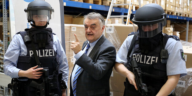Herbert Reul (CDU, M), Nordrhein-Westfalens Innenminister, steht zwischen zwei Polizisten, die ballistische Schutzhelme tragen. Herbert Reul (CDU, M), Nordrhein-Westfalens Innenminister, steht zwischen zwei Polizisten, die ballistische Schutzhelme tragen.