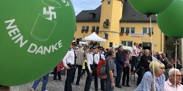 Menschen stehen auf einem Marktplatz in Apolda und demonstrieren gegen ein Rechtsrock-Konzert. Sie haben grüne Ballons mit der Aufschrift „Nazis? Nein, danke“ dabei Menschen stehen auf einem Marktplatz in Apolda und demonstrieren gegen ein Rechtsrock-Konzert. Sie haben grüne Ballons mit der Aufschrift „Nazis? Nein, danke“ dabei
