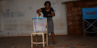 Eine Frau an einer Wahlurne