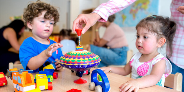 Ein Junge und ein Mädchen beim Spielen an einem Tisch Ein Junge und ein Mädchen beim Spielen an einem Tisch