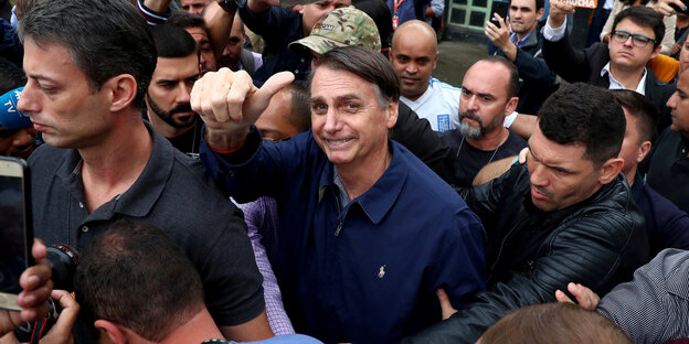 Jair Bolsonaro in einer Menschenmenge, er zeigt den Daumen nach oben Jair Bolsonaro in einer Menschenmenge, er zeigt den Daumen nach oben